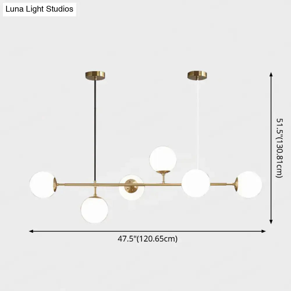 Modern gold metal island pendant light featuring brass and white glass globe with sleek minimalist design for dining room