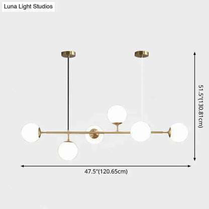 Modern gold metal island pendant light featuring brass and white glass globe with sleek minimalist design for dining room