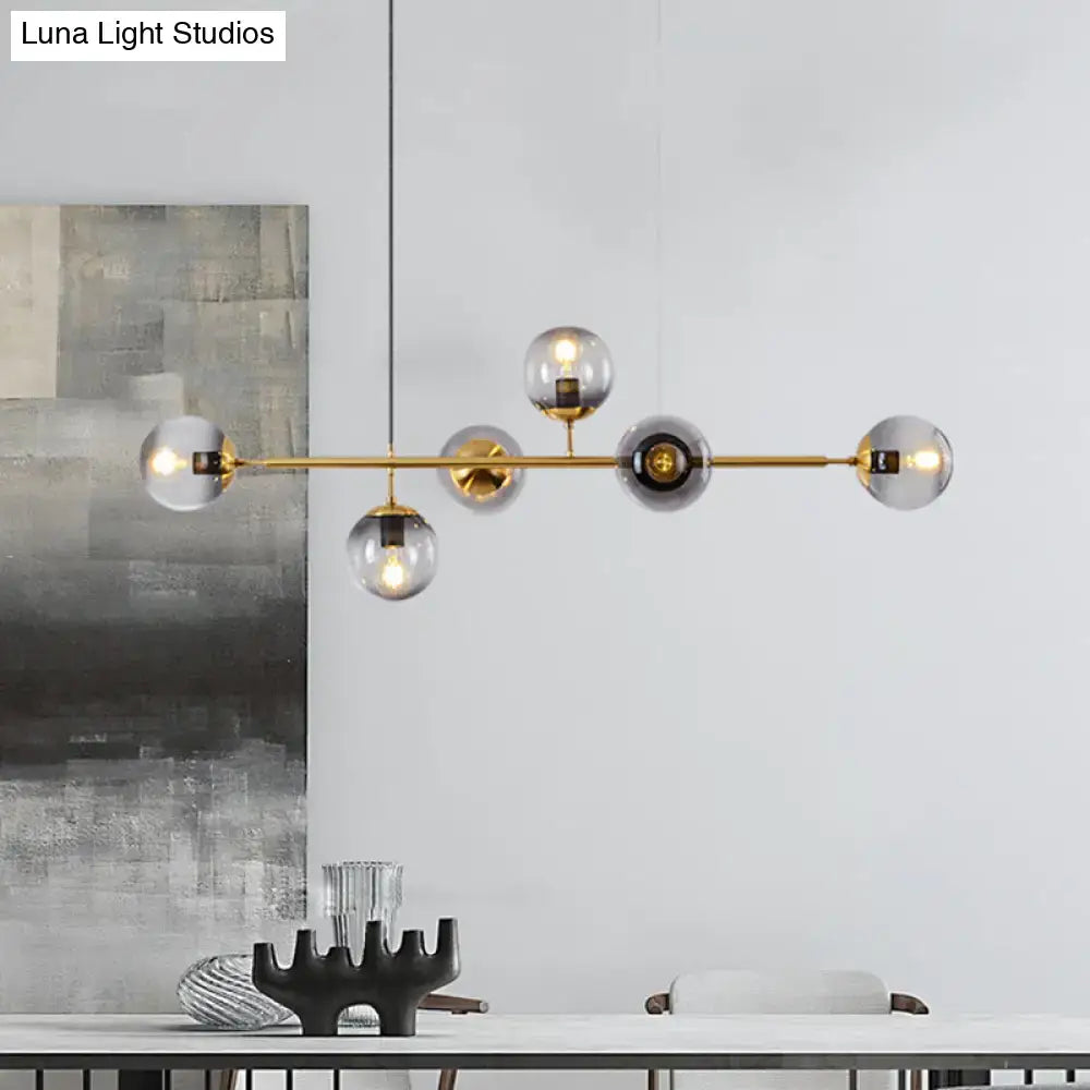 Modern gold metal island pendant with clear and smoky glass globe shades for dining room lighting