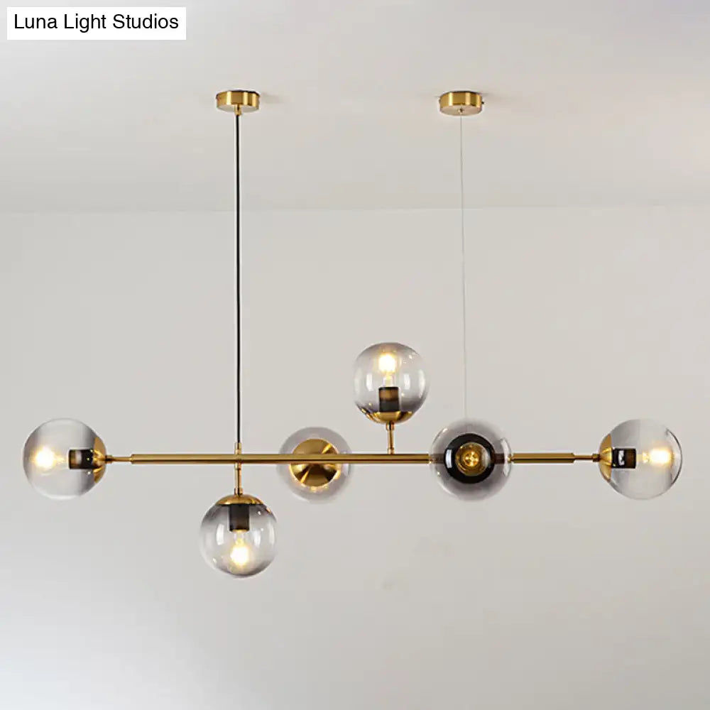 Modern gold metal island pendant with clear glass globe bulbs and blue spheres for dining room lighting