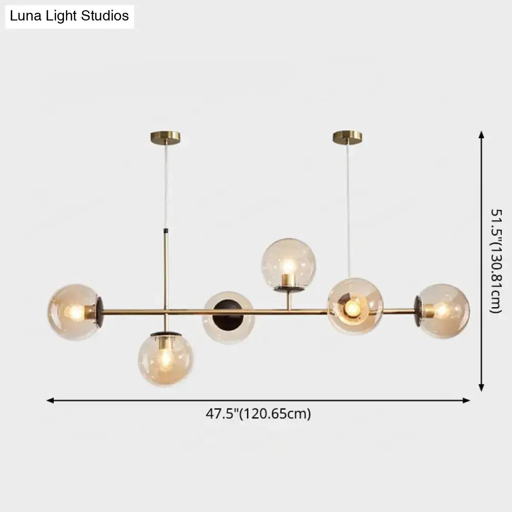 Modern gold metal island pendant with brass and smoked glass globe design and blue glass spheres for dining room