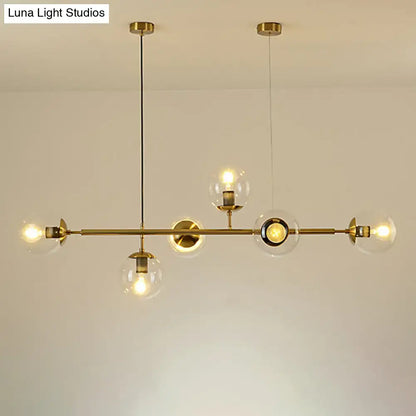 Modern gold metal island pendant with clear glass globe shades and exposed bulbs for dining room lighting