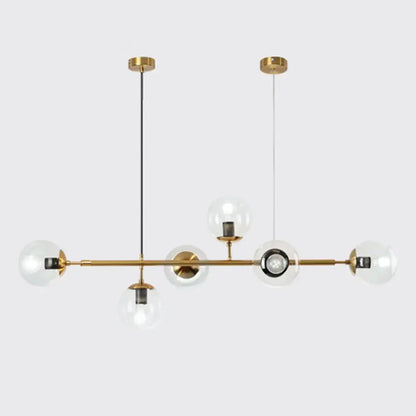 Modern gold metal island pendant with brass chandelier design, clear glass globe bulbs, and black cord accents for dining room