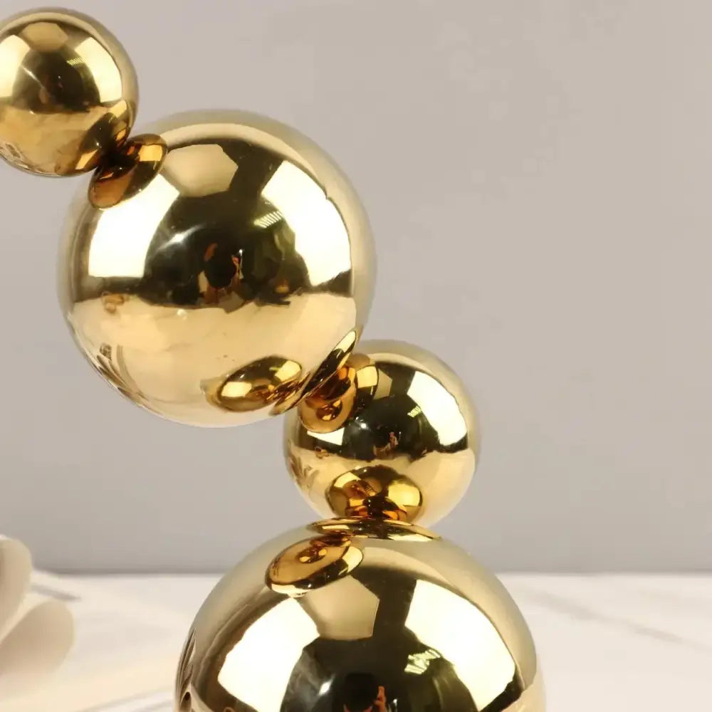 Modern gold metal spheres stacked art pieces featuring interconnected cascading design for living room decorbites decor