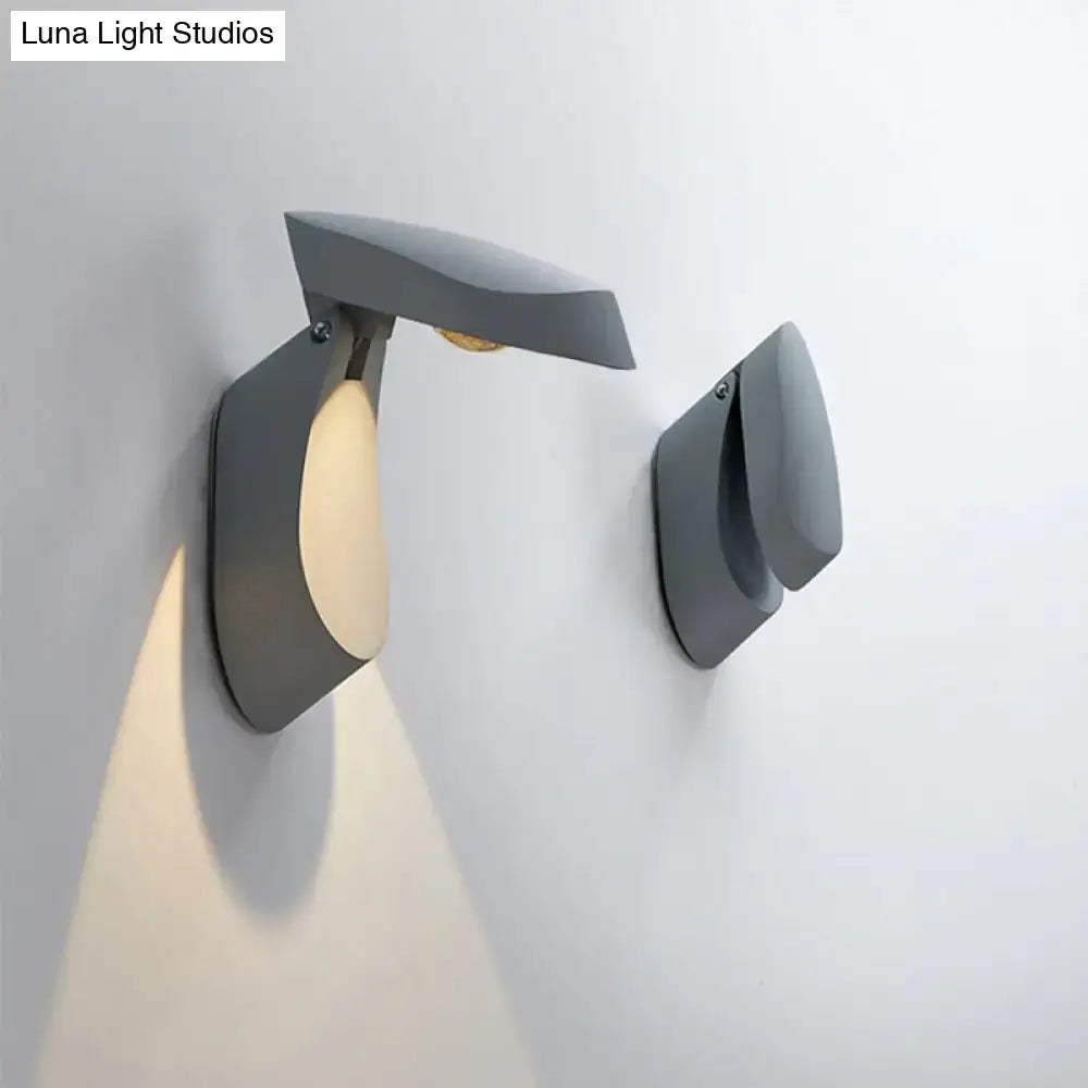 Modern gold metal wall light bedside fixture with sleek matte gray angular design and warm light emission