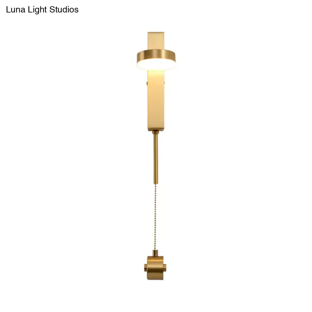 Modern gold metal wall sconce with sleek rectangular design and adjustable pull chain providing warm white light
