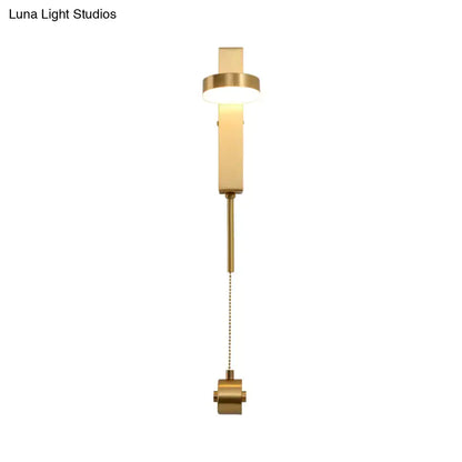 Modern gold metal wall sconce with sleek rectangular design and adjustable pull chain providing warm white light