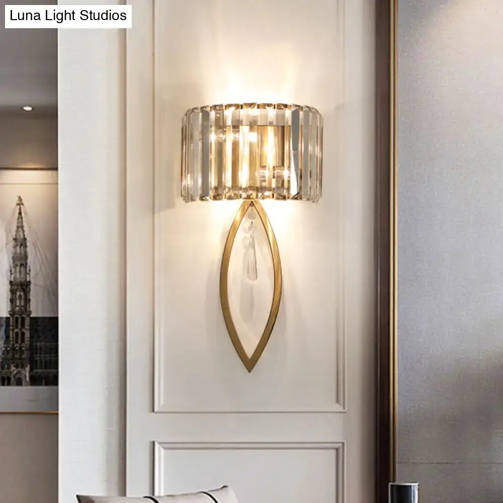 Modern gold metallic drum shade wall light with cylindrical crystal shade and teardrop base with hanging crystals