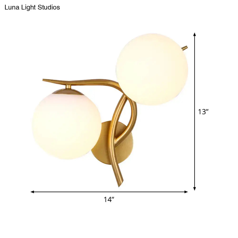 Modern gold sconce light with milk glass frosted globe shades and standard bulb base for bedroom wall fixture
