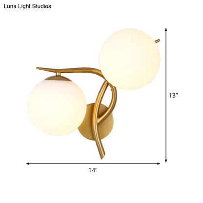 Modern gold sconce light with milk glass frosted globe shades and standard bulb base for bedroom wall fixture