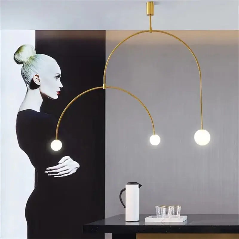 Modern gold minimalist iron chandelier with three spherical bulbs and curved metal arms for dining room pendant light decorbites black