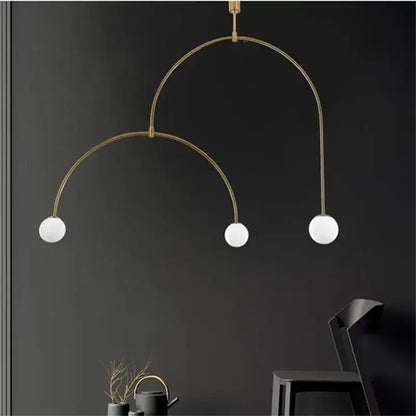 Modern gold minimalist iron chandelier featuring a brass arched pendant light with three white glass bulbs for dining room decorbites black