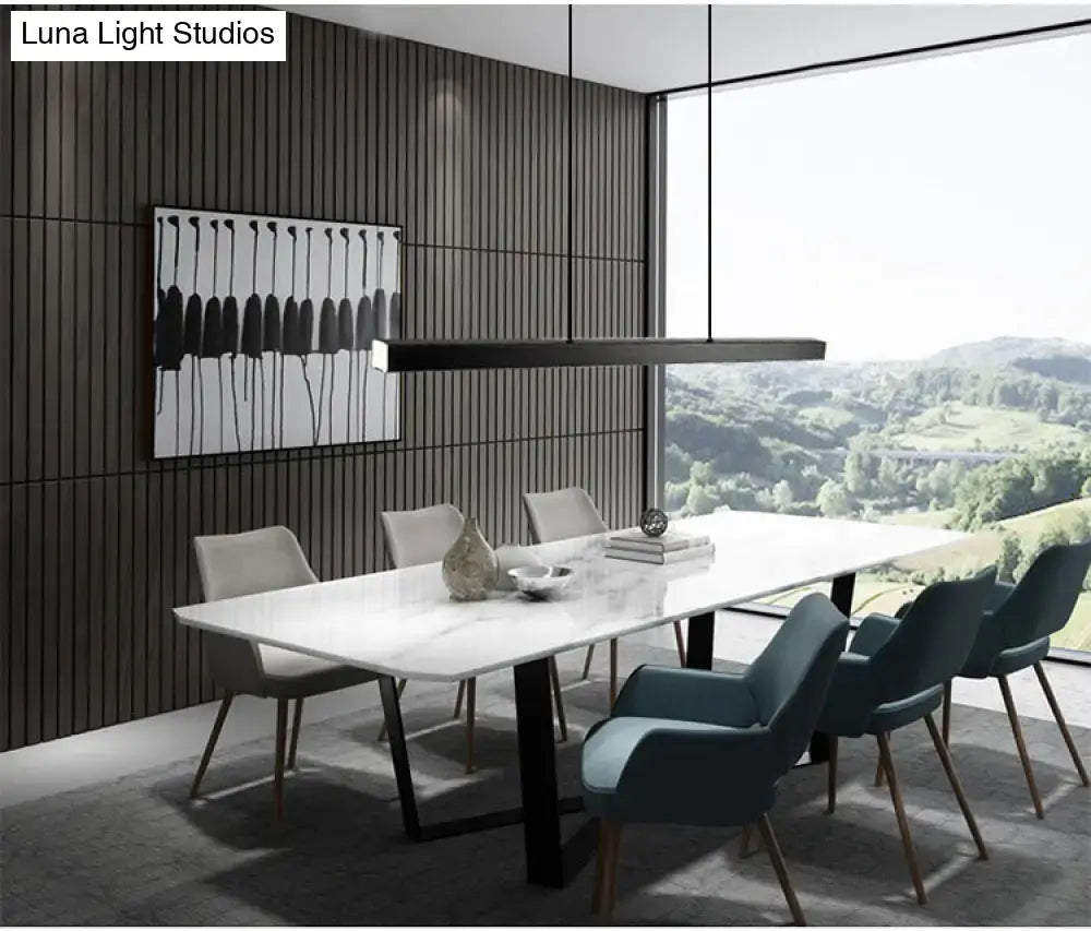 Modern gold minimalist led suspension lamp light fixture above a white marble dining table with black metal legs