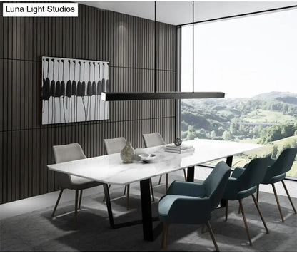 Modern gold minimalist led suspension lamp light fixture above a white marble dining table with black metal legs