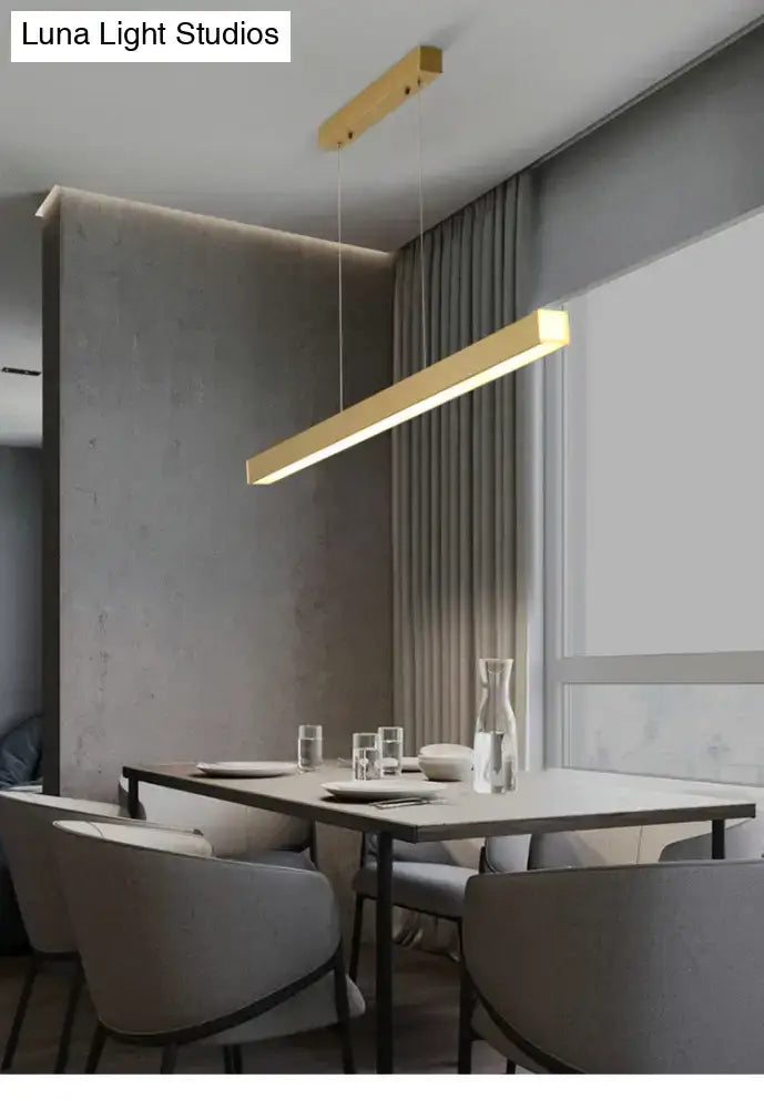 Modern gold minimalist led suspension lamp metal light fixture with sleek design hanging above dining table
