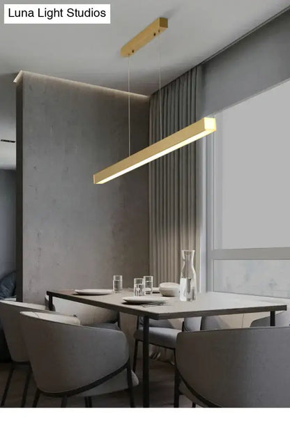 Modern gold minimalist led suspension lamp metal light fixture with sleek design hanging above dining table
