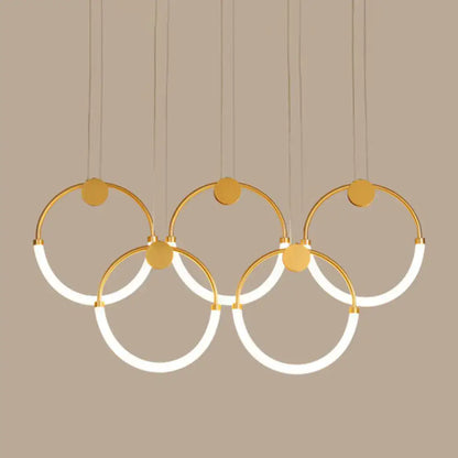 Modern gold minimalistic ring pendant light with five interlocking illuminated rings for living room use