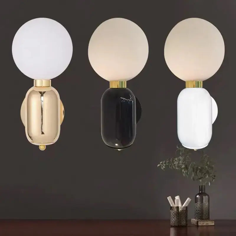 Three modern spherical frosted glass ball wall lamps with decorbites gold mirror and black and white metallic bases