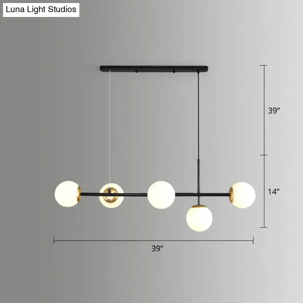 Modern black metal modo island chandelier with five milk white frosted glass globes and gold black accents for restaurants