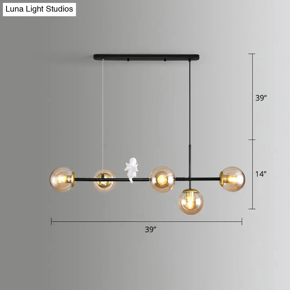 Black metal modo island pendant light with five amber glass globes and a milk white angel figurine for restaurants