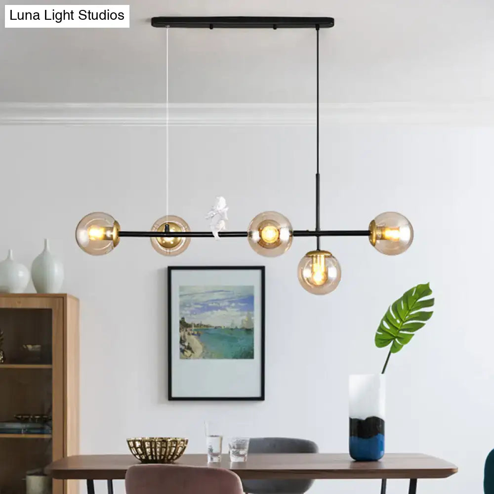 Modern black metal modo island chandelier with five amber glass globe bulbs gold black finish for restaurants
