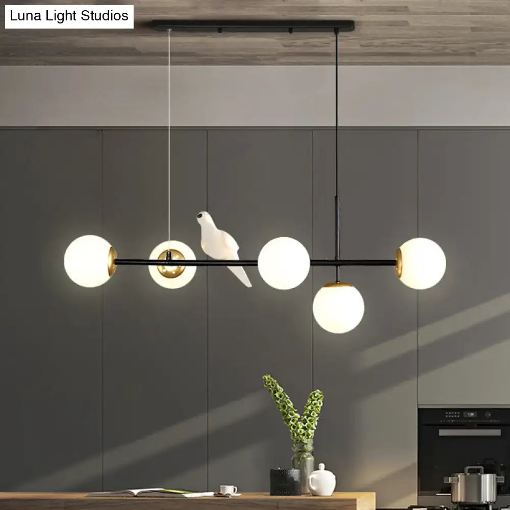Modern black metal modo island chandelier with five milk white frosted glass globes and a white ceramic dove centerpiece