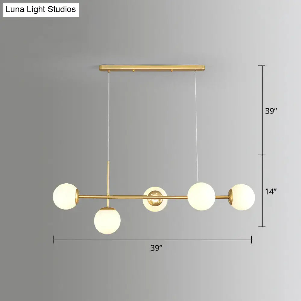 DecorBites Modo Island gold-toned pendant light with four milk white frosted glass globe bulbs in linear design for restaurants