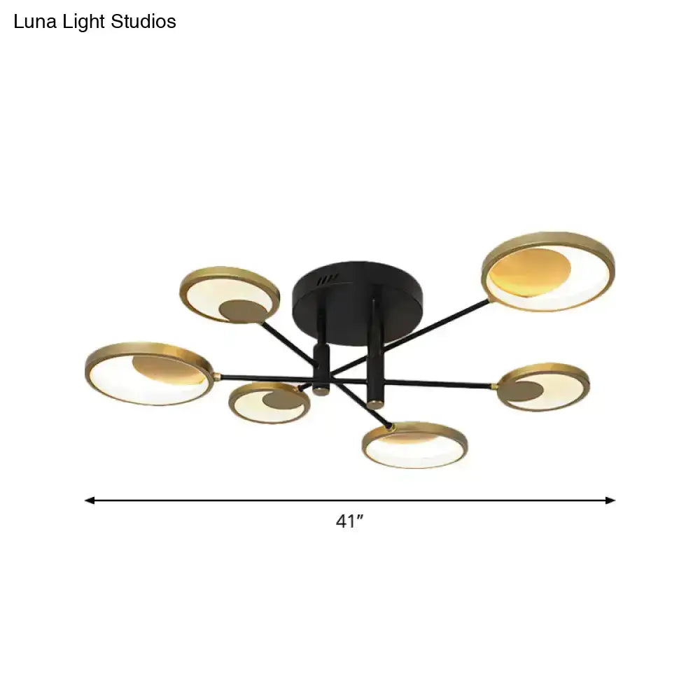 Modern gold molecule ceiling mount chandelier with six circular gold-rimmed fixtures emitting warm glow