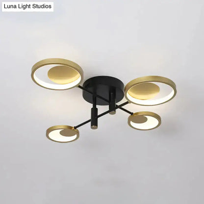 Modern gold molecule ceiling mount chandelier with black base and four illuminated gold rings for living room lighting