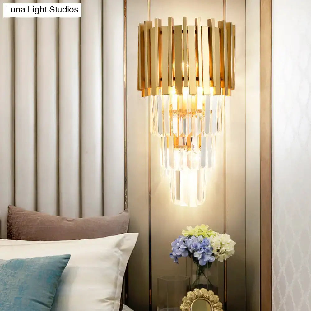 Modern gold wall light with vertical brass bars and cascading clear crystal prism tiers for dining room illumination