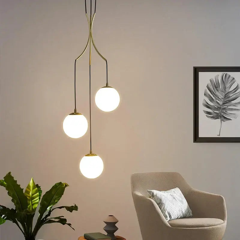 Modern brass decorbites gold nordic pendant light with three glowing spherical glass shades for dining room use