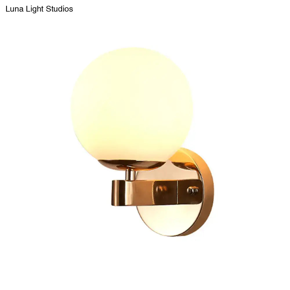Modern gold opal glass wall light with frosted globe and polished brass for elegant living room lighting