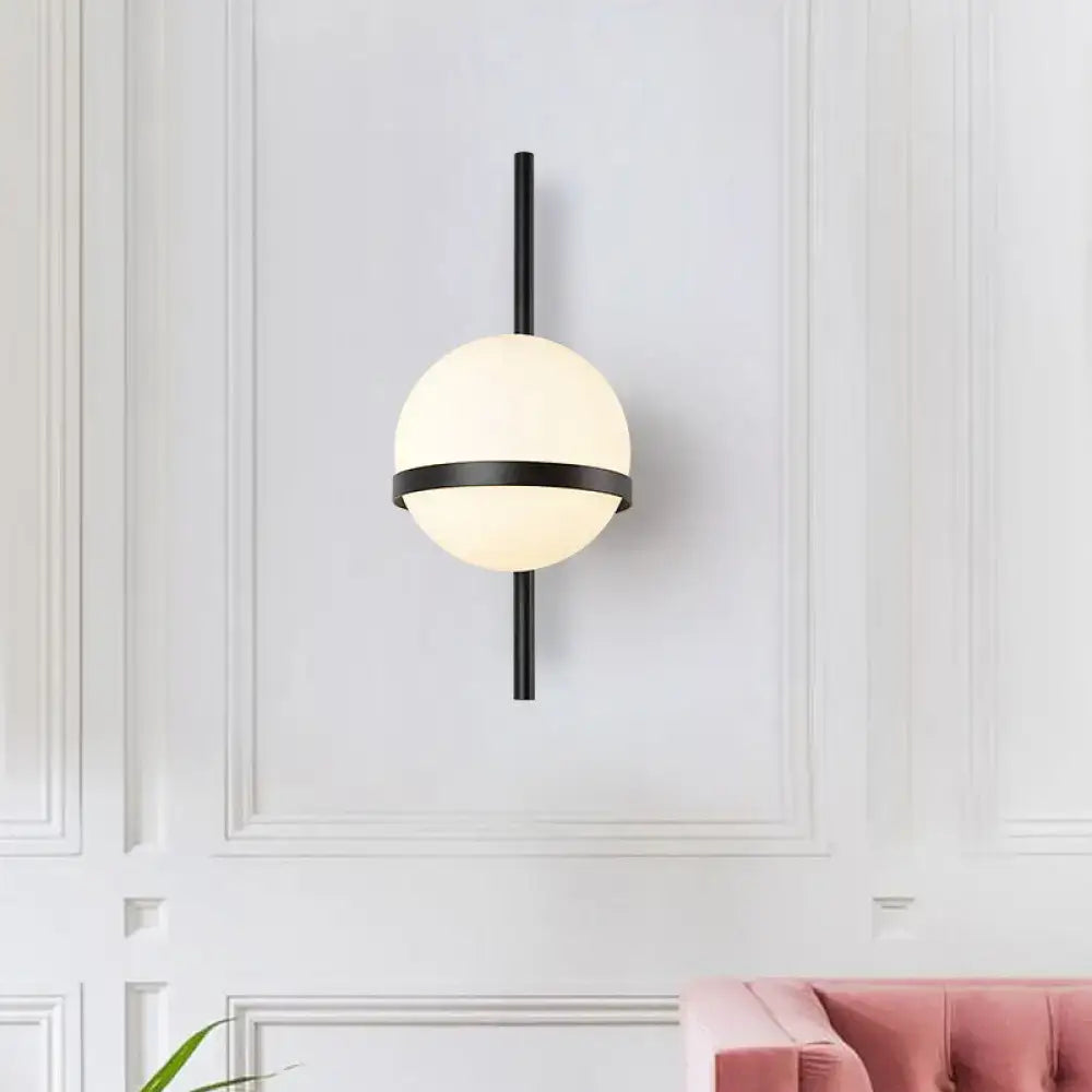 Modern black metal wall sconce with frosted opal glass orb and horizontal accent band for living room lighting