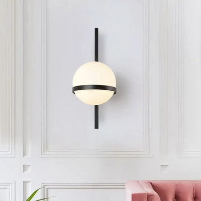 Modern black metal wall sconce with frosted opal glass orb and horizontal accent band for living room lighting