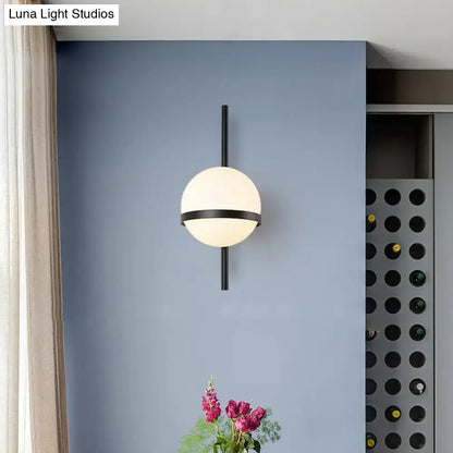 Modern gold opal glass orb wall sconce with matte white opal glass globe and black metal frame for living room lighting