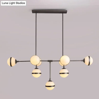 Modern black metal orb chandelier with six warm glass globes and silver gold bulb base perfect for restaurant lighting