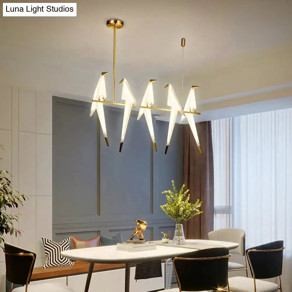 Modern gold origami bird pendant light with five white bird-shaped fixtures for dining room decor