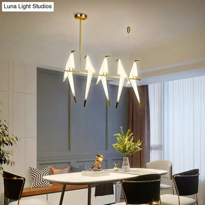 Modern gold origami bird pendant light with five white bird-shaped fixtures for dining room decor