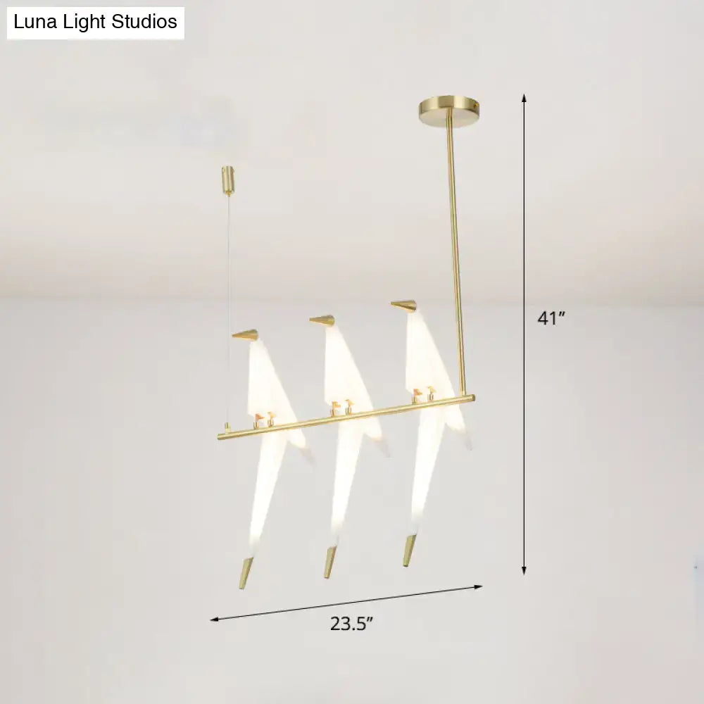 Modern gold origami bird pendant light with three stylized bird-shaped fixtures and white translucent shades for dining room decor