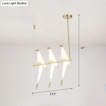 Modern gold origami bird pendant light with three stylized bird-shaped fixtures and white translucent shades for dining room decor