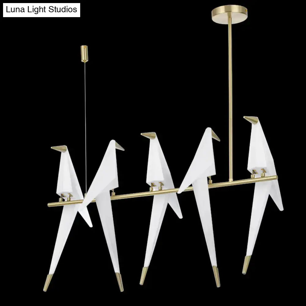 Modern gold origami bird pendant light featuring white origami crane design with gold-toned metal accents for dining room decor