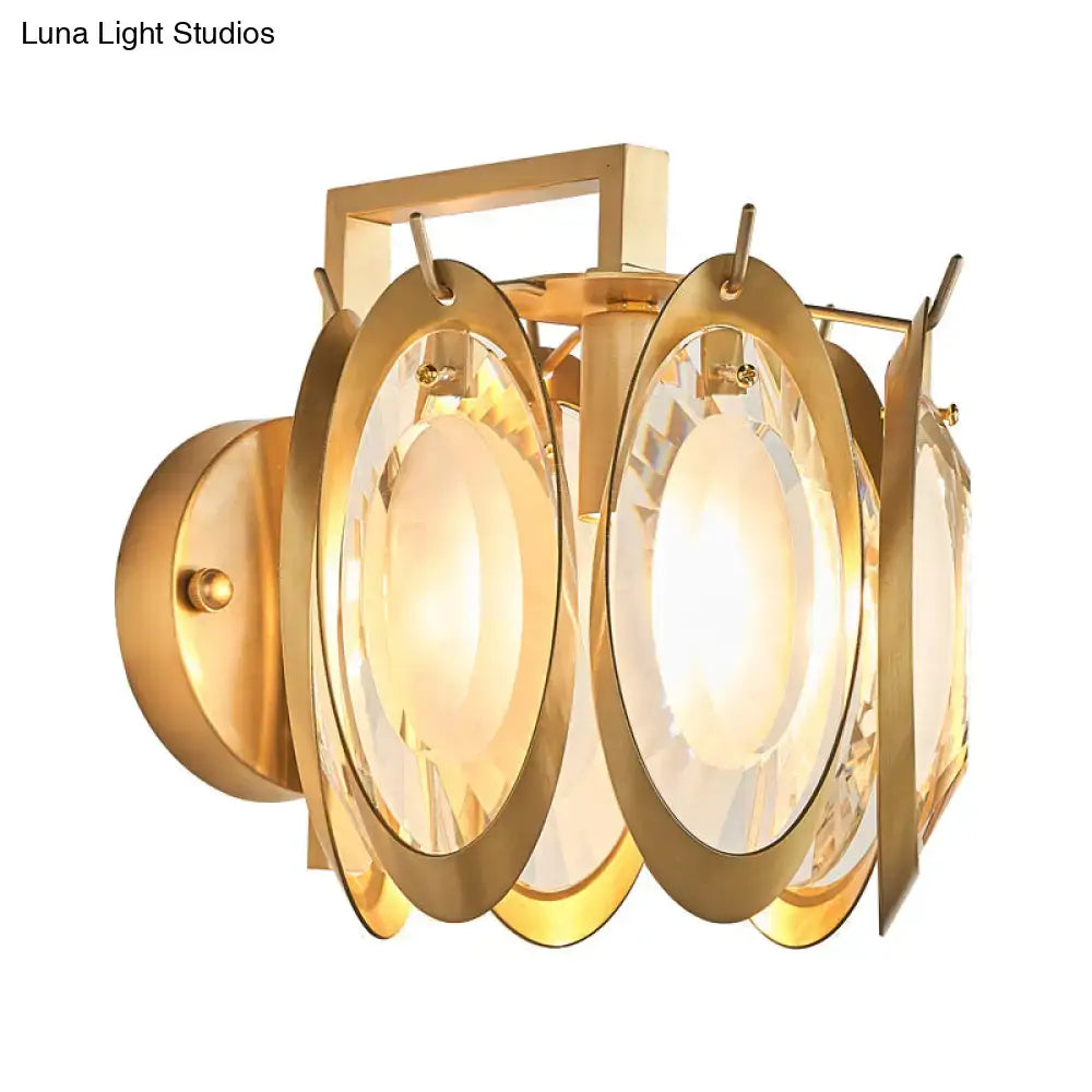Modern gold oval crystal wall light featuring a gold-toned geometric frame with faceted crystal panels wall light fixture