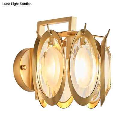 Modern gold oval crystal wall light featuring a gold-toned geometric frame with faceted crystal panels wall light fixture
