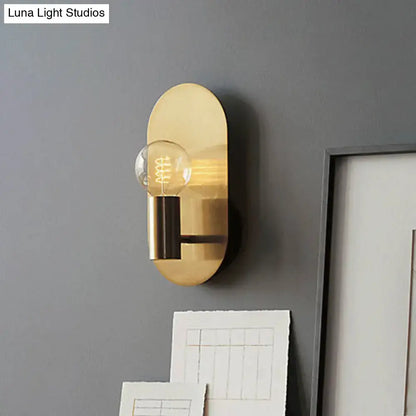 Modern gold oval sconce with bare bulb metal shade featuring a clear filament bulb for bedroom lighting