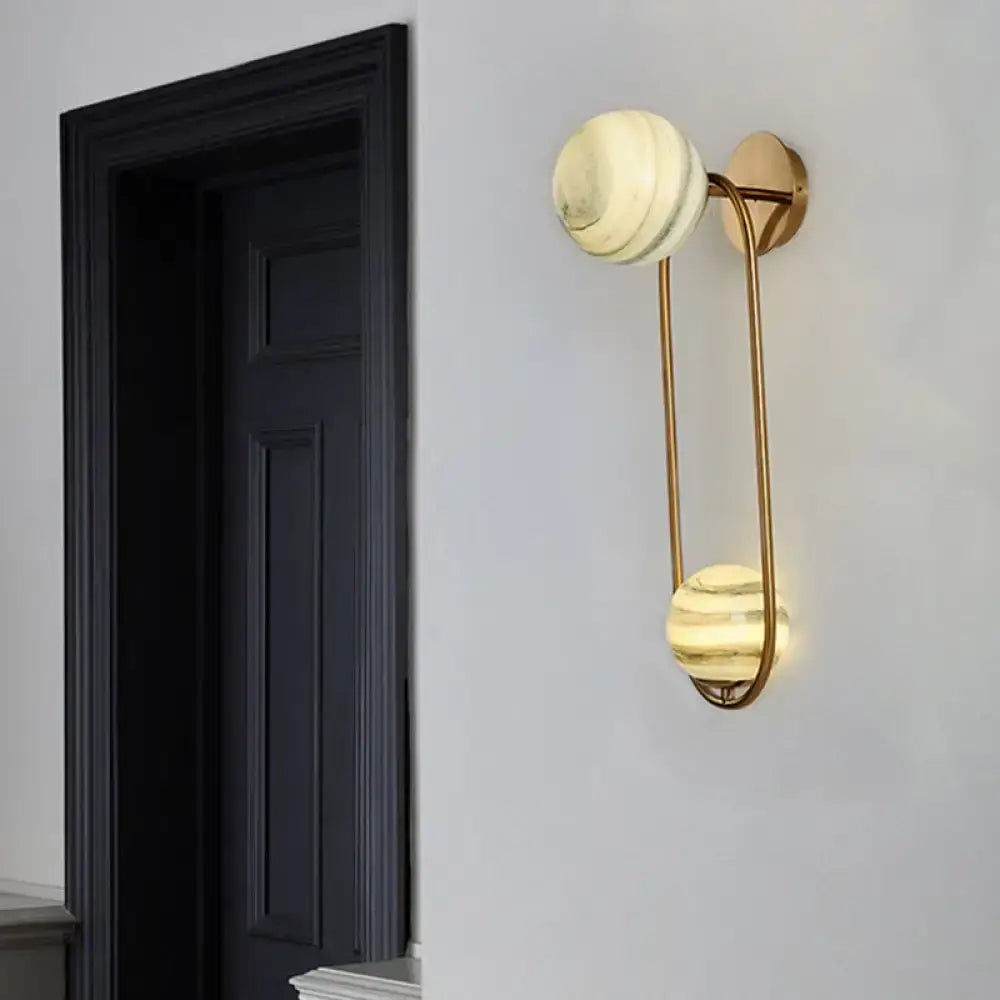 Modern gold oval wall sconce light fixture with cream marble shades and curved metal arms for living room sconce light