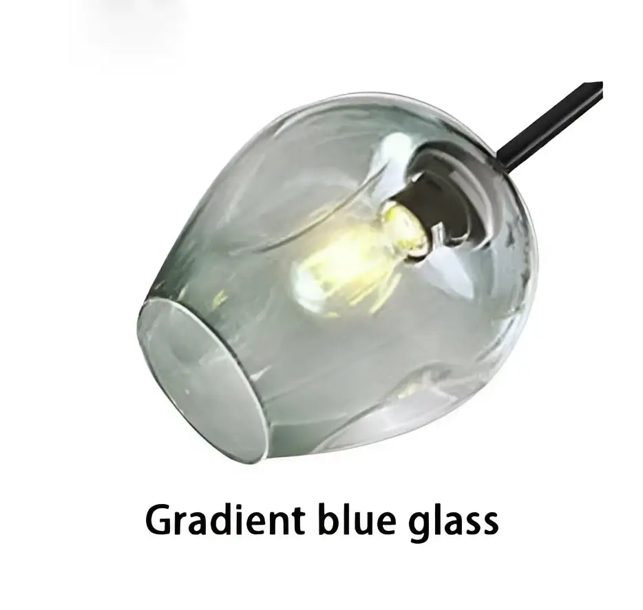 Modern blue glass pendant light with visible filament bulb and painted metal gold finish for dining room use