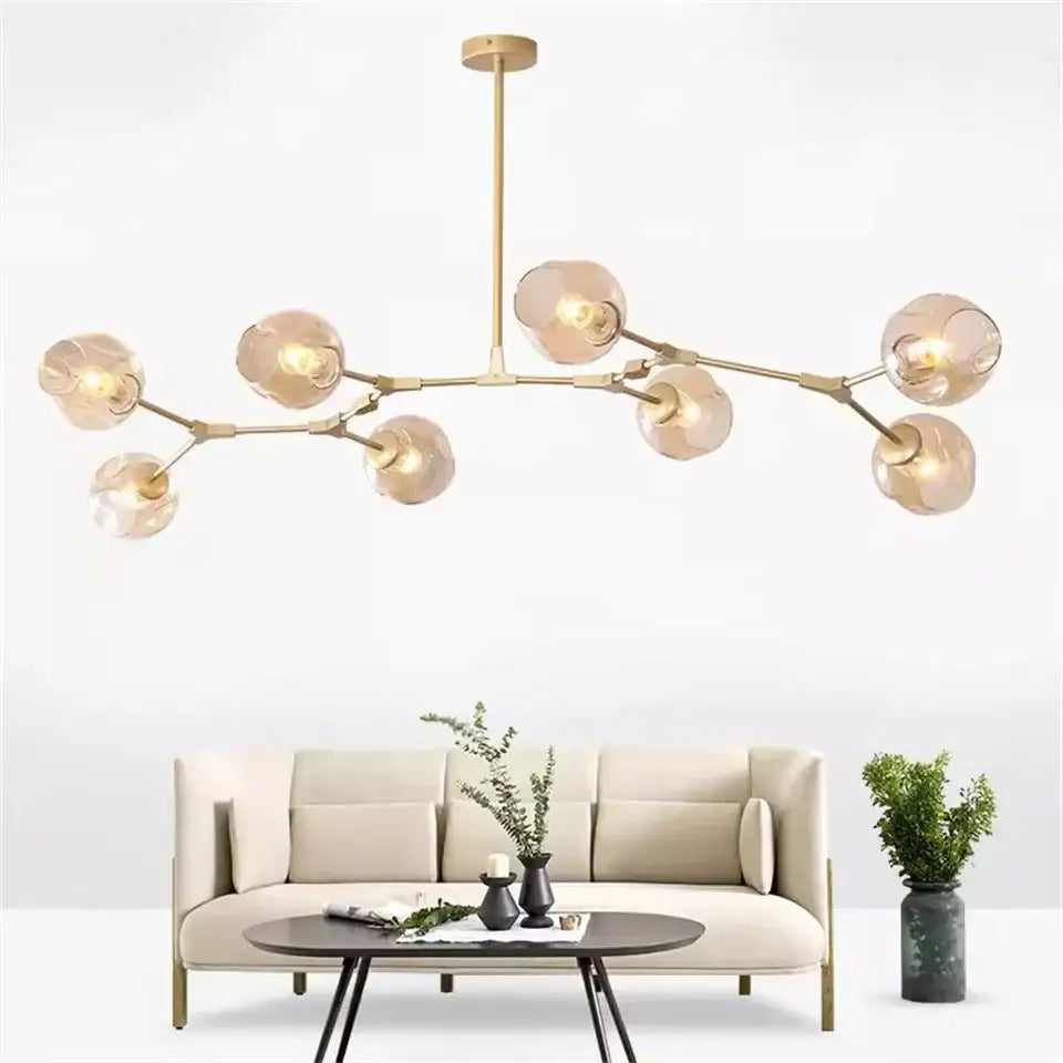 Modern gold painted metal pendant light with multiple frosted glass globes and metal finish for dining room use