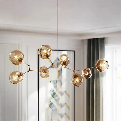 Modern gold painted metal pendant light with multiple glass globes in a branching design for dining room use