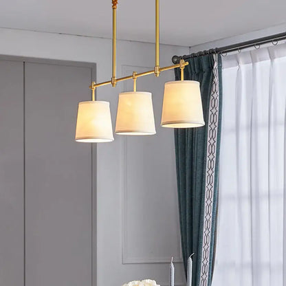 Decorbites™ modern gold pendant lamp with three gold-toned brass lights and off-white fabric shades for dining rooms