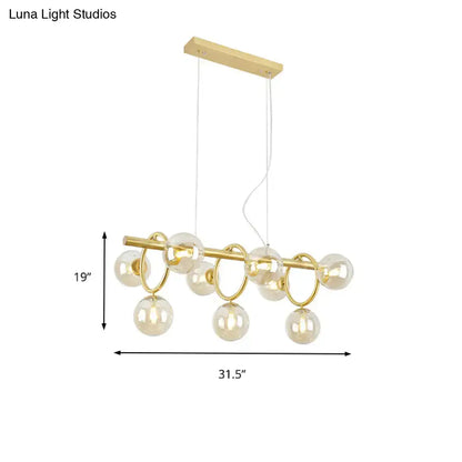 Gold-toned DecorBites™ Nordic pendant light with clear cognac glass spheres and circular metal rings suspended from wood mount